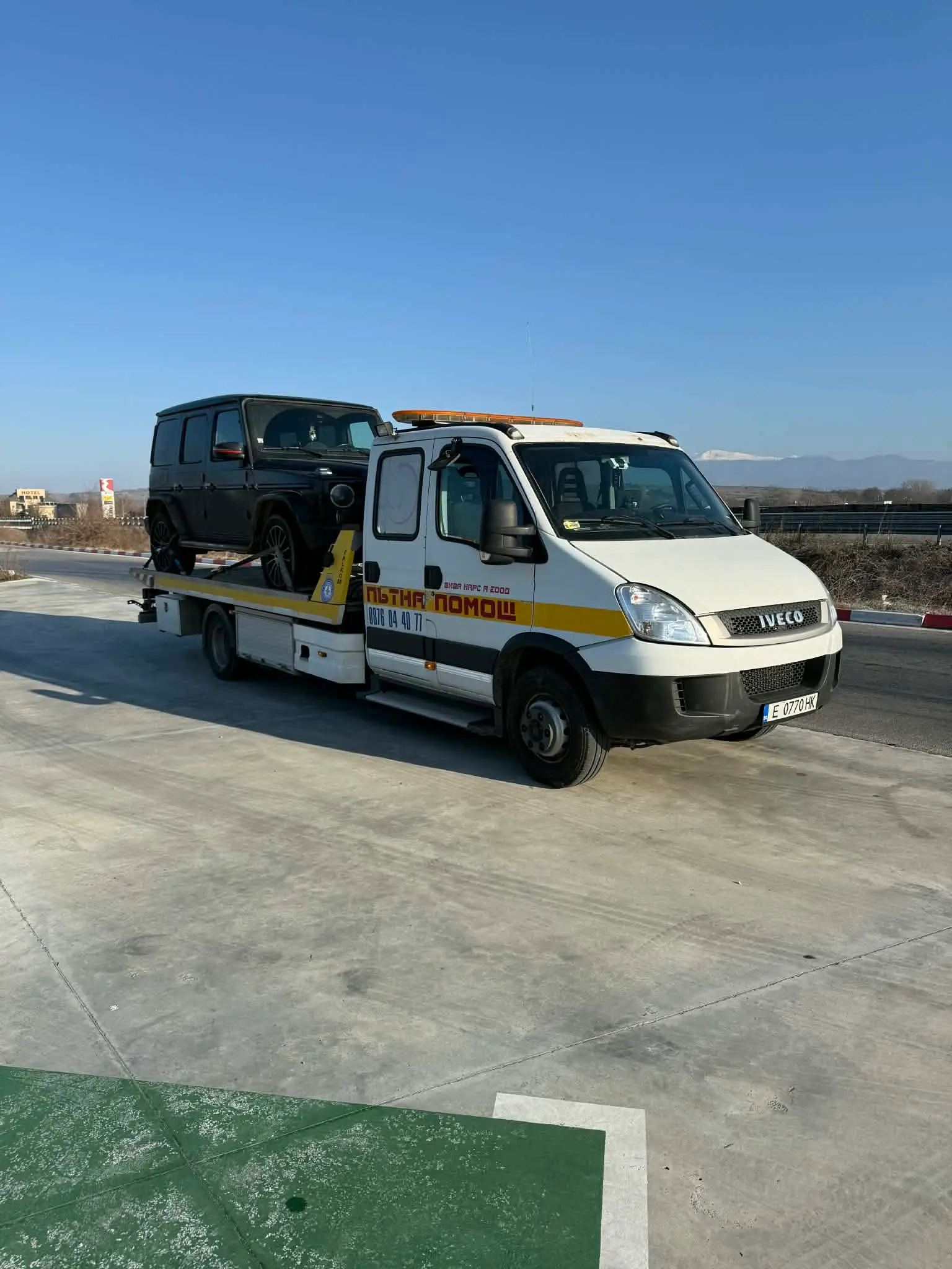 Бял репатрак IVECO с Mercedes G-Class на магистрала